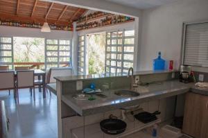 a kitchen with a counter with two sinks in it at Lindo sítio com pesca, trilhas, piscina, barco e muita diversão in Itatiba