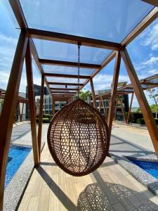 a rattan swing hanging from a glass roof at K AVENUE GC kk house in Kota Kinabalu