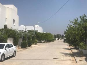 a white car parked on the side of a street at La douceur de Hammamet in Yasmine