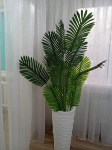 a white vase with a green plant in it at Островок Уюта in Aktobe +13 photos