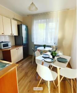 a kitchen with a white table and chairs in a room at Dom wakacyjny Blisko Plaży in Gdynia