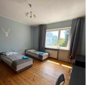 two beds in a room with a large window at Dom wakacyjny Blisko Plaży in Gdynia