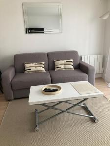 ein Wohnzimmer mit einer Couch und einem Couchtisch in der Unterkunft Grand studio hyper centre avec balcon TOUT REFAIT MARS 2025 in Deauville