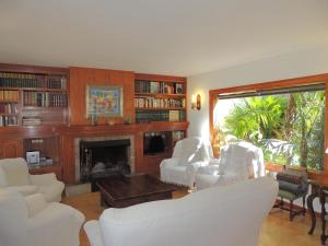 sala de estar con sillas blancas y chimenea en Villa en Andratx con piscina privada, en Andratx