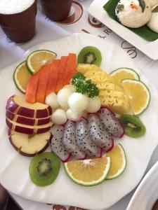 a plate of fruit and vegetables on a table at Golden galaxy hotels and resorts pvt ltd in Pīrthala