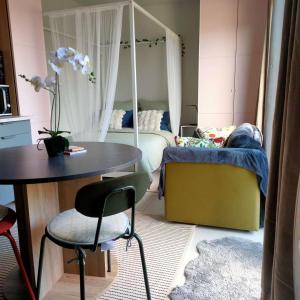 a small bedroom with a bed and a table and chair at Charming Studio Lumineux Climatisé in Audenge +23 photos