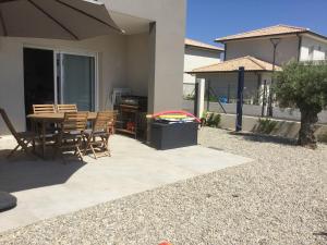 eine Terrasse mit einem Tisch und Stühlen in einem Haus in der Unterkunft PDM Appartement Paese di Mare in Santa-Lucia-di-Moriani