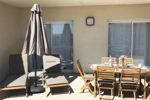 ein Esszimmer mit Tisch und Stühlen und einem Sonnenschirm in der Unterkunft PDM Appartement Paese di Mare in Santa-Lucia-di-Moriani