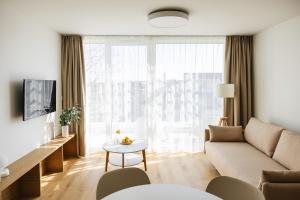 ブワディスワボボにあるPROMENADA apartamenty & spa PRZY PLAŻYのソファとテーブルのあるリビングルーム