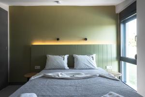 a bedroom with a bed with white sheets and a window at Theeta Villas by RentalsPro - Metamorfosi Halkidiki in Metamorfosi
