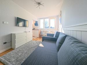 salon z niebieską kanapą i telewizorem w obiekcie Apartament Parkowy Rabka w Rabce