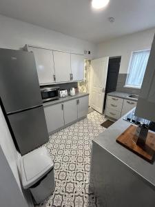 a kitchen with white cabinets and a counter top at Spaghetti House - 6 Bedroom Contractor House Sleeps 12 Parking for 3 Vans Bromford Duddeston Fort Dunlop Star City Saltley Viaduct HS2 in Birmingham
