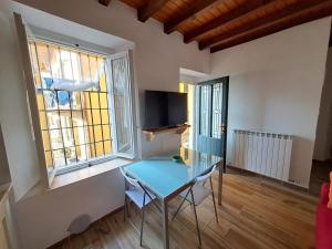 a glass table in a room with two windows at Casa Romeo lago di Como in Abbadia Lariana