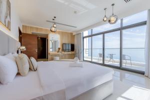 a bedroom with a large white bed and a large window at Sea and Mountain Views 6BR and Assistant's Room Villa, with Heated Pool & BBQ Area, Al Dana, Sharm, Fujairah by Deluxe Holiday Homes in Fujairah +47 photos