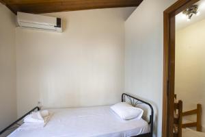 1 Schlafzimmer mit einem Bett und Klimaanlage in der Unterkunft Eria Home by RentalsPro - Trikorfo Halkidiki in Yerakiní