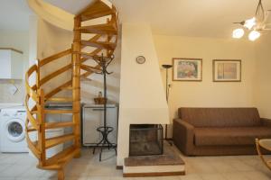 ein Wohnzimmer mit Wendeltreppe und Couch in der Unterkunft Eria Home by RentalsPro - Trikorfo Halkidiki in Yerakiní + 16 Fotos