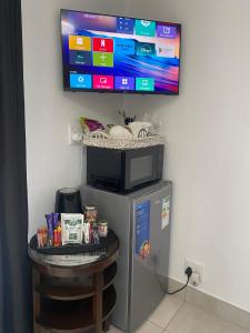 a tv on a wall above a small refrigerator at Sleep on 489 in Pretoria