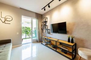 a living room with a flat screen tv on a wall at Golden Lake in Arraial do Cabo