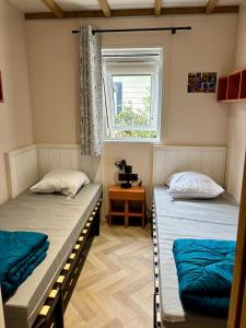 two beds in a room with a window at Le Domaine des Pins in Saint-Hilaire-de-Riez