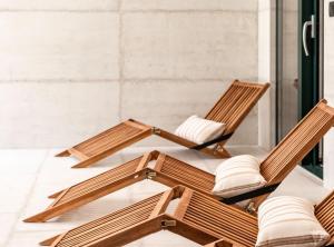 a group of wooden lounge chairs in a room at Luxury Private Spa Apartment with Heated Pool & Sauna and Sea View in Cavtat +23 photos