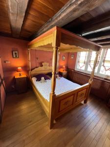un lit à baldaquin dans une chambre avec deux fenêtres dans l'établissement Gîte des Amoureux, à Colmar
