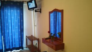Habitación con espejo y TV en la pared. en Hotel Flesvos, en Pefkohori