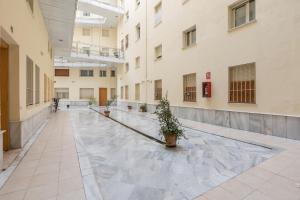 an empty hallway of a building with potted plants at Dumonde Parking in Seville
