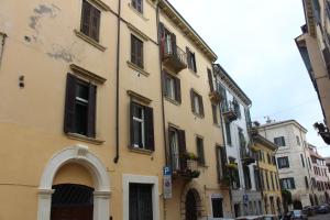 een geel gebouw met een gewelfde deuropening in een straat bij Residenza Star in Verona