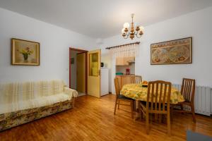een woonkamer met een tafel en een bank bij Apartment Luciana in Umag