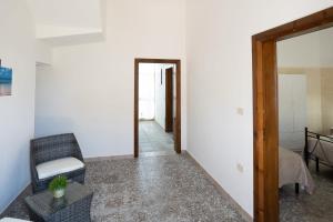 a living room with a chair and a table at Casa Lu Paparoni 1 a 130 mt dalla spiaggia Specchiarica di San Pietro in Bevagna in Torre Colimena