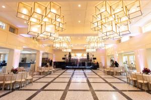 a banquet hall with tables and chairs and chandeliers at The Albion Summit in Summit
