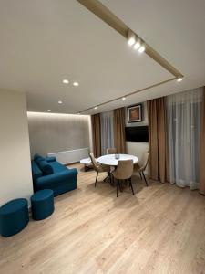 a living room with a table and a blue couch at Deluxe Aparthotel Central in Zalău