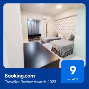 a hotel room with two beds and a tv at The Square Apartemen Service Twin Suite with WiFi NetFlix 50Inchi in Surabaya