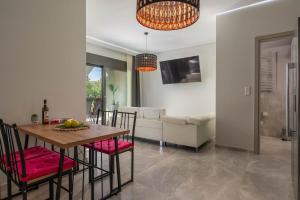 a dining room and living room with a table and chairs at Luxury Olea Valley Apartment - Nikiti Poolside Gem in Nikiti