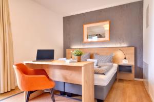 a bedroom with a desk and a bed with a laptop at Ferienwohnung Waldkauz 23 im Wreecher Idyll Rügen by ruyastay in Putbus