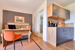 a kitchen with a desk with a laptop on it at Ferienwohnung Waldkauz 23 im Wreecher Idyll Rügen by ruyastay in Putbus