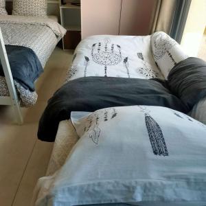 a couch with pillows on it in a room at Charming Studio Lumineux Climatisé in Audenge