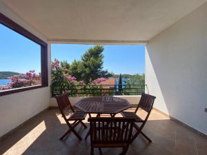a patio with a table and chairs on a balcony at Villa Maslinica in Maslinica