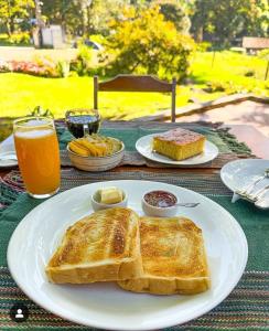 a white plate with toast and bread on a table at Recanto da Susanne in Resende