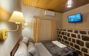 a room with a couch and a tv on a wall at Recanto da Susanne in Resende
