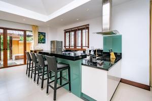 a kitchen with a counter with stools at a bar at Villa SALSA PRIVATE POOL in Ko Yao Noi