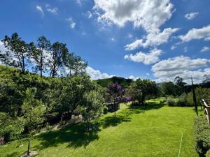 an open field with trees and a blue sky with clouds at Villaggio Torrelaguna Cabana Roma in Cunha