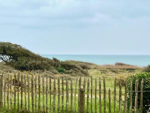 a wooden fence with the ocean in the background at L'Estran in Les Sables-d'Olonne