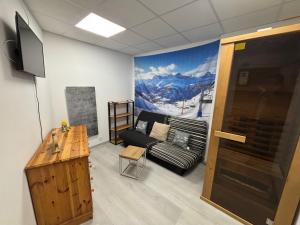 a living room with a couch and a mural of a mountain at Résidence Belle Hutte 2 in La Bresse