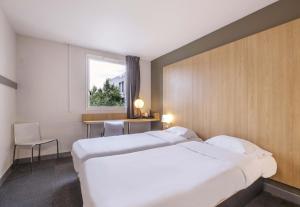 a hotel room with a large bed and a window at B&B HOTEL La Rochelle Centre in La Rochelle +37 photos