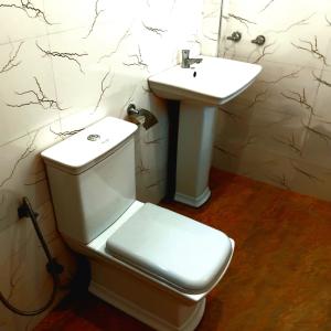 a bathroom with a toilet and a sink at Dramatic Green Cottage in Udawalawe