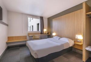 拉罗谢尔B&B HOTEL La Rochelle Centre的有一张大床和一扇窗户的酒店房间