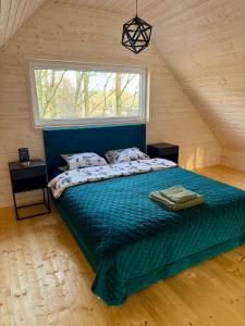 a bedroom with a large bed in a attic at Greenwood I - Dom z Jacuzzi i furtką do lasu in Tuliska