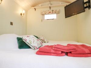 Una cama con dos toallas encima. en Woodlands Retreat Shepherd's Hut, en Woodbridge