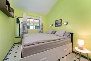 ein kleines Schlafzimmer mit einem Bett mit grünen Wänden in der Unterkunft Bungalow Angelika Campo Golf in San Bartolomé de Tirajana + 30 Fotos